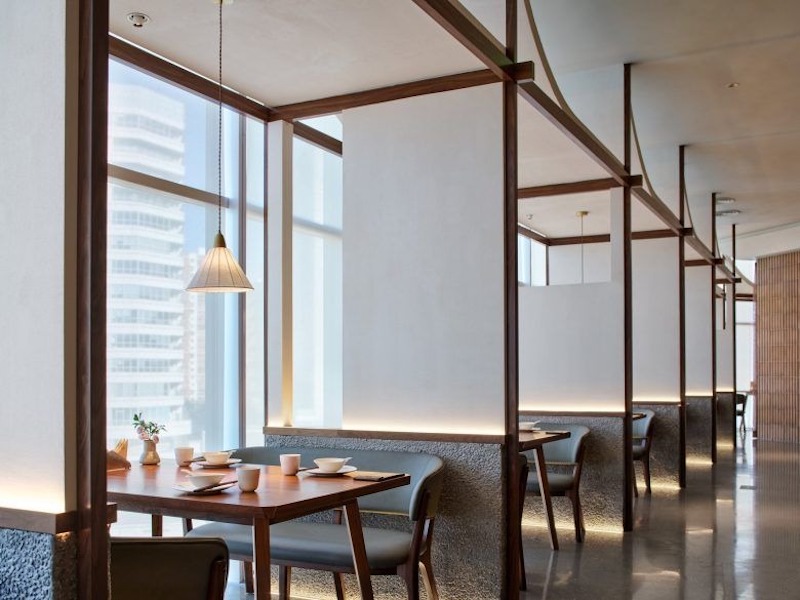 Cửa kính lớn trong nhà hàng Nhật Bản phong cách hiện đại (Modern Japanese) tận dụng ánh sáng tự nhiên, kết nối không gian trong và ngoài một cách hài hòa 