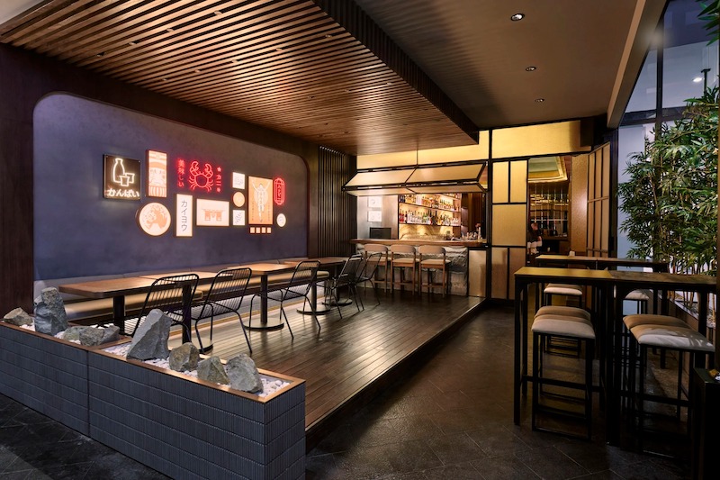 Nhà hàng Nhật Bản phong cách Izakaya mang không khí ấm cúng, thân mật với bàn ghế gỗ thấp và bố cục gần gũi, tạo cảm giác chào đón 