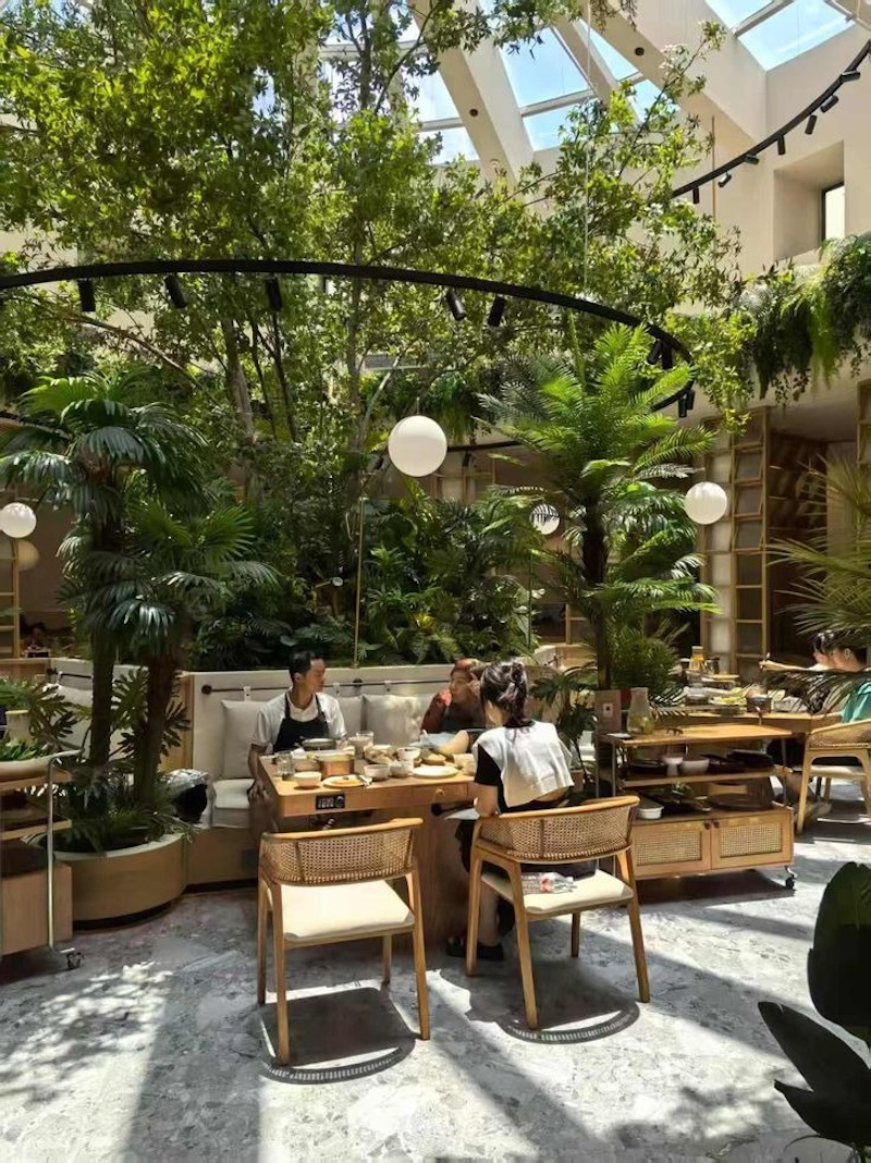 Nhà hàng sân vườn có thể bố trí khu vực thưởng thức cafe sáng ngoài trời kết hợp tiểu cảnh và ghế bọc nệm êm ái để khách thư giãn 