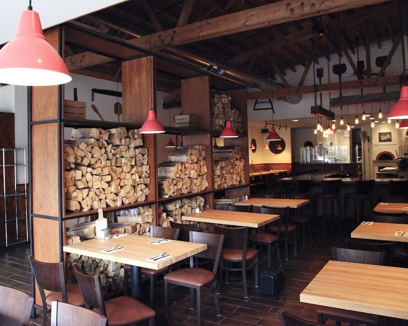 Quán pizza phong cách truyền thống thường kết hợp bàn ghế gỗ, tranh tường Ý và chất liệu tự nhiên để nhấn mạnh sự mộc mạc nhưng đầy chiều sâu văn hóa