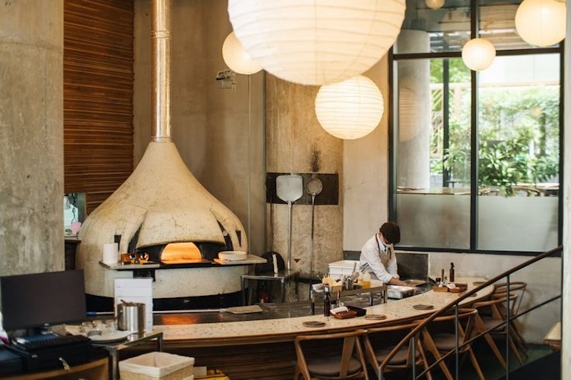 Bếp mở trong quán pizza công nghiệp vừa tiện thao tác cho nhân viên, vừa trở thành điểm nhấn trực quan thu hút khách hàng ngay khi bước vào