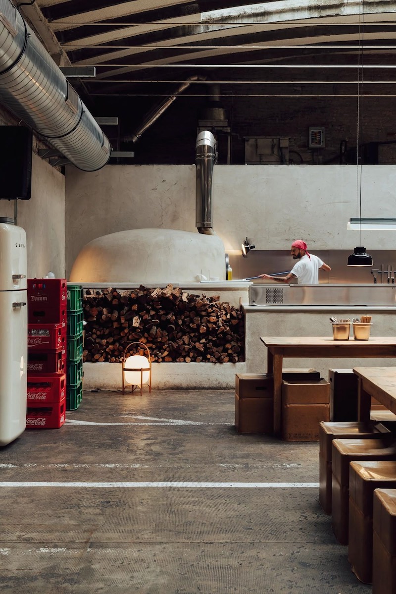 Thiết kế bếp mở tối giản giúp khách quan sát quy trình làm pizza, tăng trải nghiệm trực quan mà vẫn giữ không gian gọn gàng, ngăn nắp 