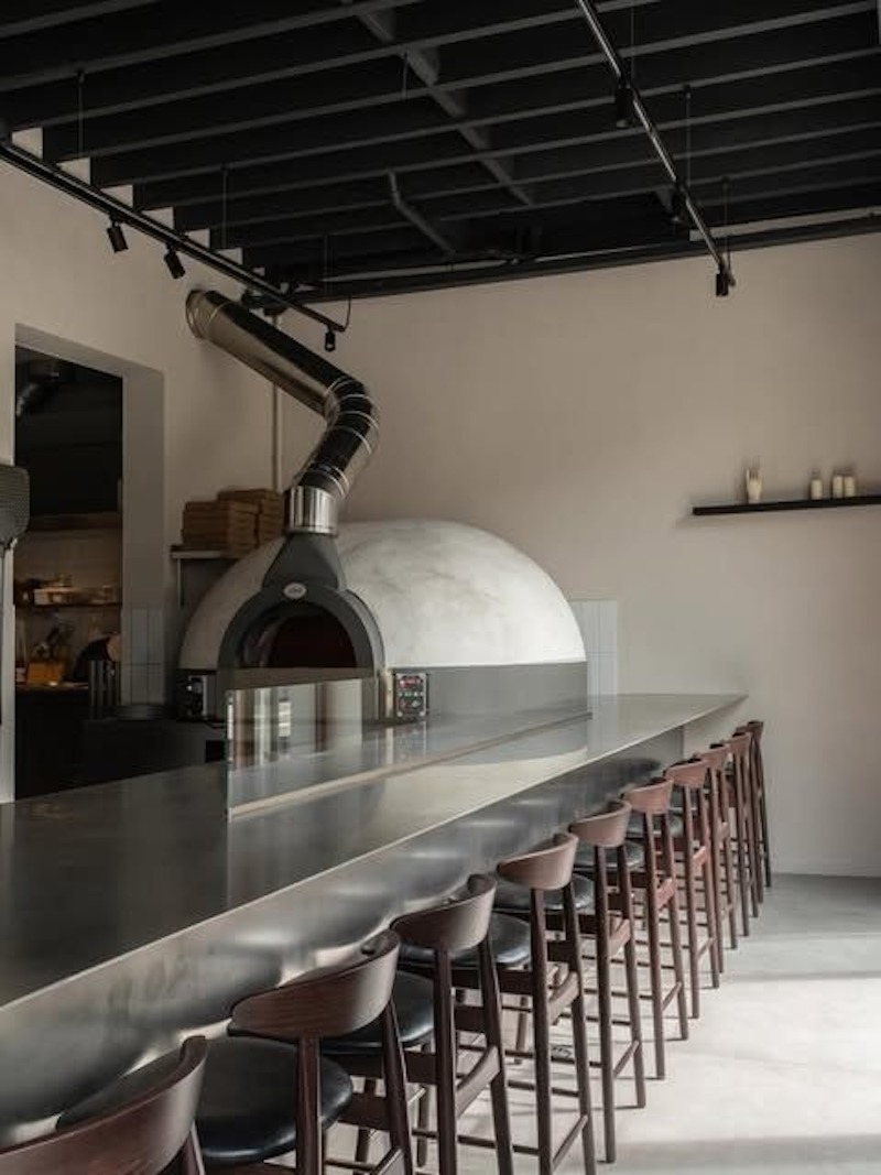 Quán pizza phong cách hiện đại nổi bật với đường nét tinh gọn, vật liệu mới như kính, kim loại và gỗ sáng màu, tạo không gian trẻ trung, năng động  