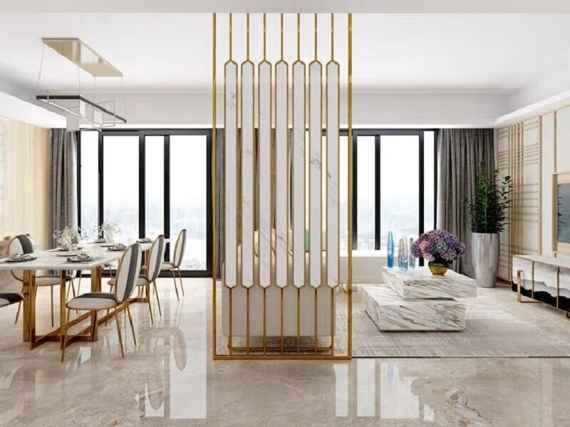 Không gian phòng khách thông thoáng với điểm nhấn kim loại inox mạ vàng PVP cao cấp, kết hợp hệ cửa kính lớn đón ánh sáng, mang lại phong cách hiện đại