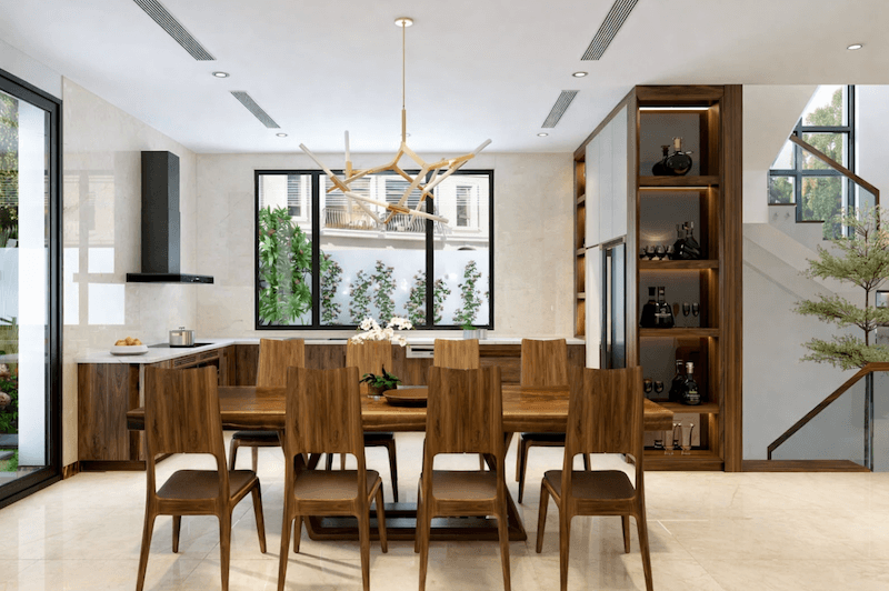 Không gian bếp - ăn liên thông với bàn ăn gỗ nguyên khối, hệ tủ bếp ốp gỗ kết hợp đá sáng màu tạo cảm giác sang trọng