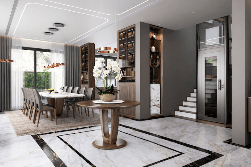 Không gian sảnh và phòng ăn được tổ chức liền mạch,với bàn console trung tâm và thang máy kính giúp tăng chiều sâu không gian và định hình trục giao thông rõ ràng