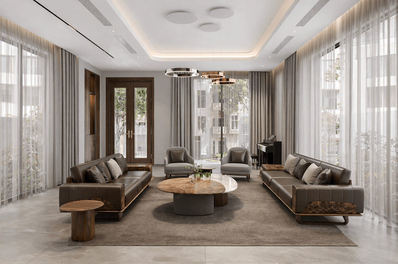 Không gian phòng khách được tổ chức đối xứng, tận dụng hệ cửa kính và rèm mỏng hai lớp để đưa ánh sáng tự nhiên vào sâu bên trong, tạo cảm giác thoáng rộng