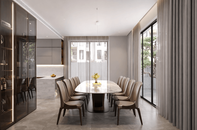 Khu vực bàn ăn được bố trí gọn gàng trong không gian mở, kết hợp bàn đá trung tâm và hệ cửa kính lớn giúp đón sáng tự nhiên, tạo cảm giác sang trọng nhưng vẫn ấm cúng