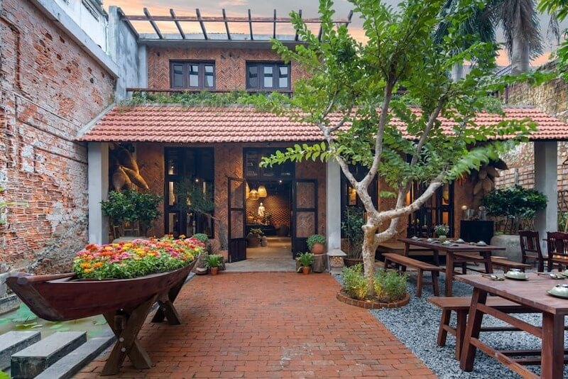 Nhà hàng chay phong cách sân vườn ưu tiên không gian mở, nhiều cây xanh, mặt nước và ánh sáng tự nhiên để tạo cảm giác thư giãn