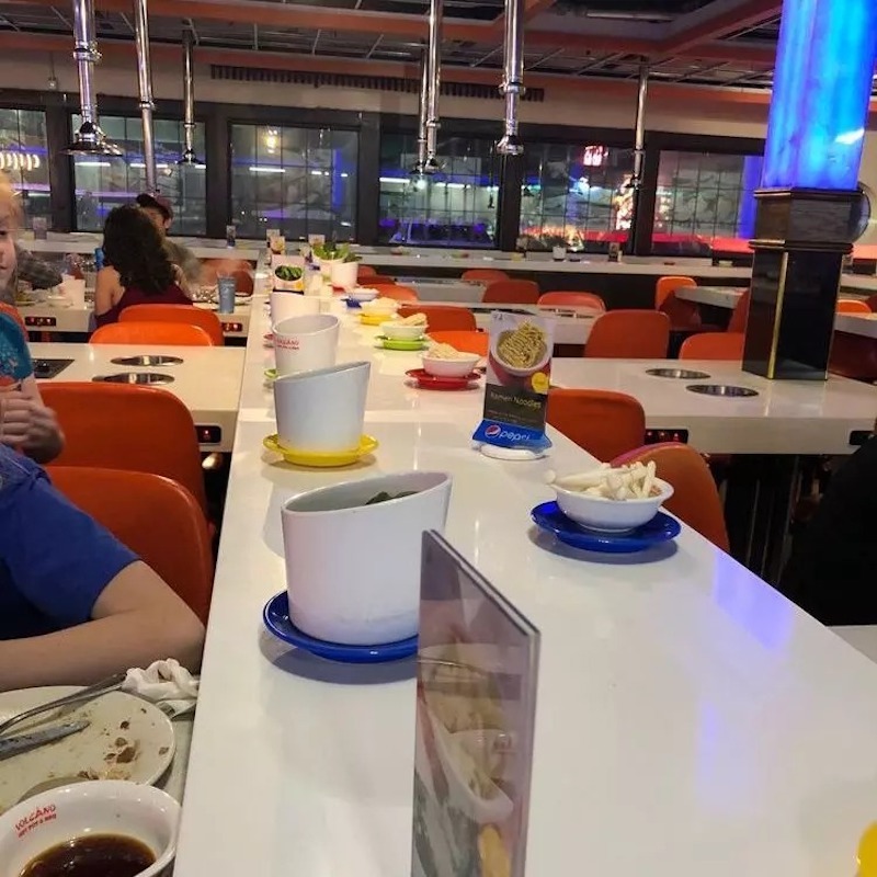 Ánh sáng bố trí dọc băng chuyền trong nhà hàng lẩu băng chuyền tạo điểm nhấn đồng thời cung cấp đủ sáng cho trải nghiệm ăn uống 