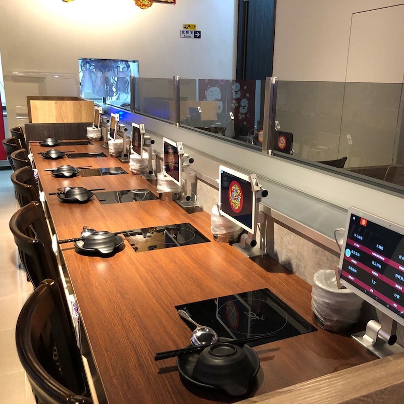 Nhà hàng lẩu băng chuyền phong cách tối giản tập trung công năng, sử dụng ít chi tiết thừa và tông màu trung tính, tạo không gian gọn gàng 