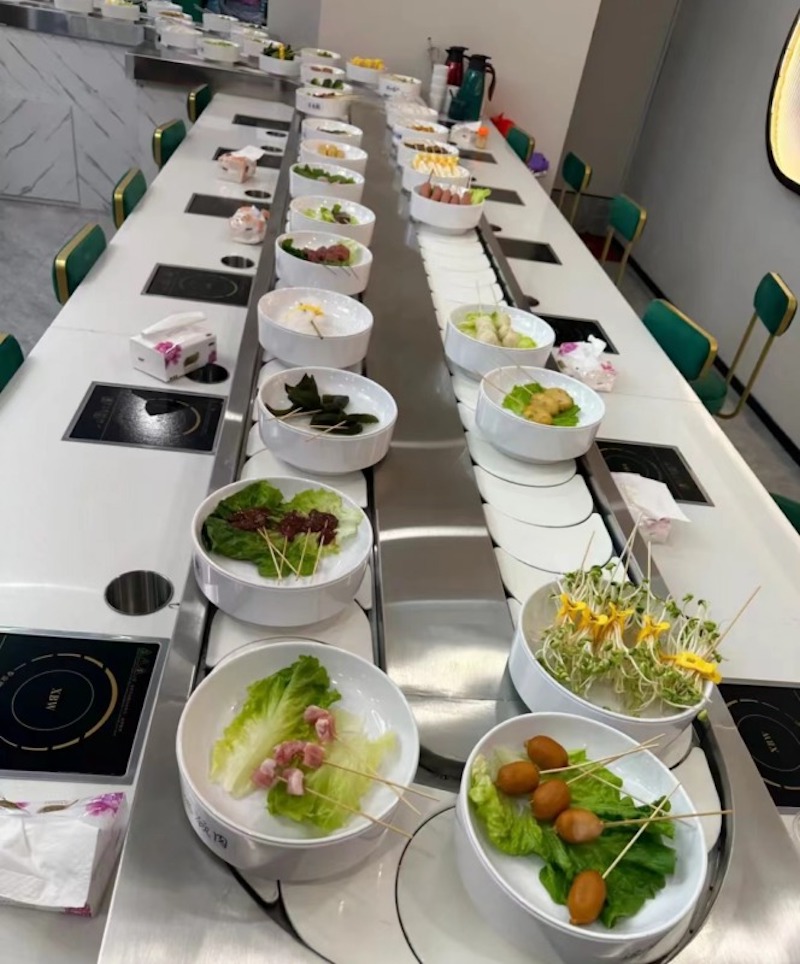 Sàn và tường nhà hàng lẩu băng chuyền sử dụng vật liệu dễ lau chùi, chống trơn trượt, mang lại cảm giác sạch sẽ và hiện đại