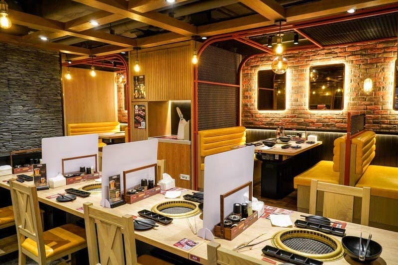 Thiết kế quán lẩu nướng nhỏ (diện tích khoảng 60m2) phong cách Industrial cần tối ưu lối đi bằng cách sắp xếp bàn ghế theo trục dọc, kết hợp hệ thống hút khói âm sàn để giữ không gian thông thoáng