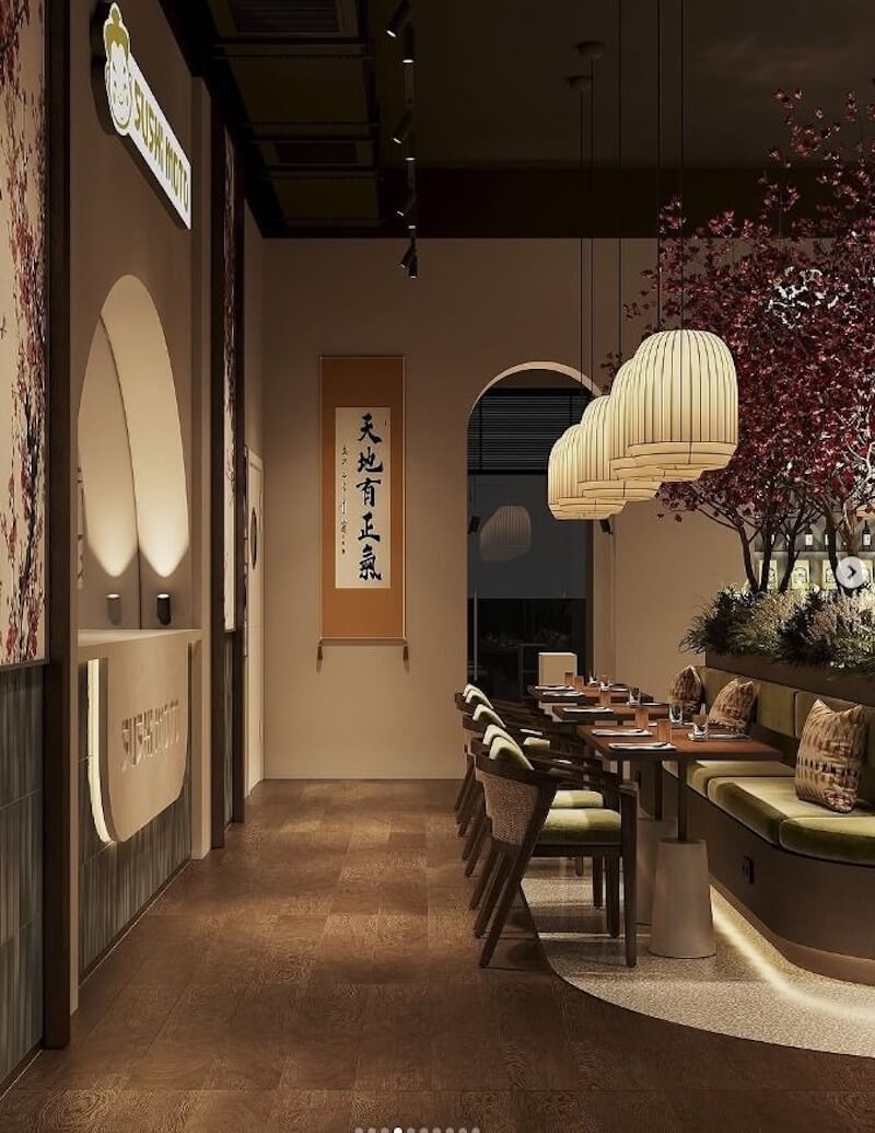 Sự kết hợp giữa mảng tường màu be mộc mạc, đèn lồng giấy thủ công và cây hoa anh đào khô, tạo nên vẻ đẹp tĩnh lặng, tự nhiên và vô thường cho nhà hàng Sushi