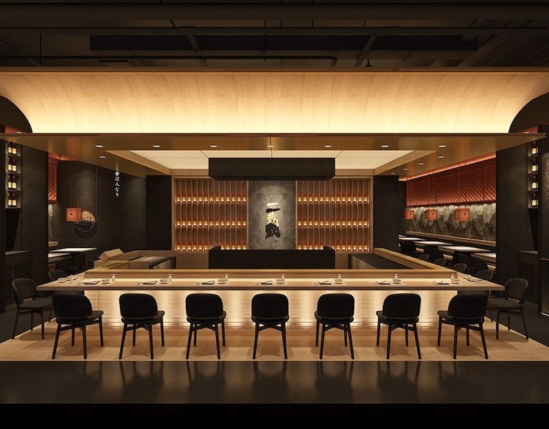 Không gian nhà hàng cao cấp với quầy gỗ dài hiện đại dưới ánh đèn vàng ấm cúng, nội thất tối giản kết hợp kệ rượu và mảng tường đá tạo cảm giác nghệ thuật