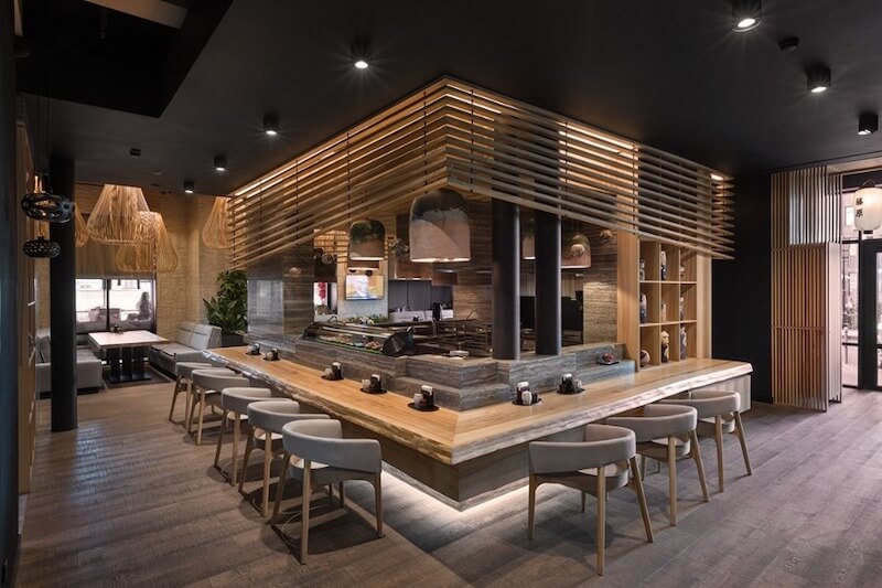 Thiết kế theo phong cách hiện đại với quầy bar ốp đá tự nhiên, mặt bàn gỗ nguyên khối, kết hợp hệ trần nan gỗ treo và đèn thả nghệ thuật