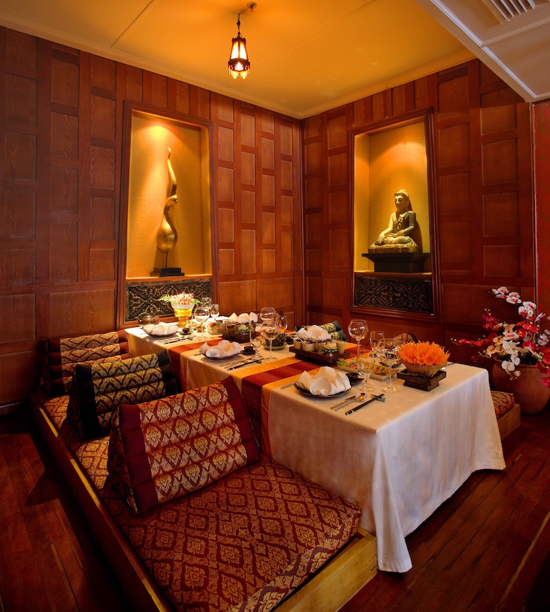 Nội thất kết hợp bàn ghế gỗ tối màu, vật liệu thiên nhiên và trang trí thủ công tạo nên không khí ấm cúng và trang nghiêm 