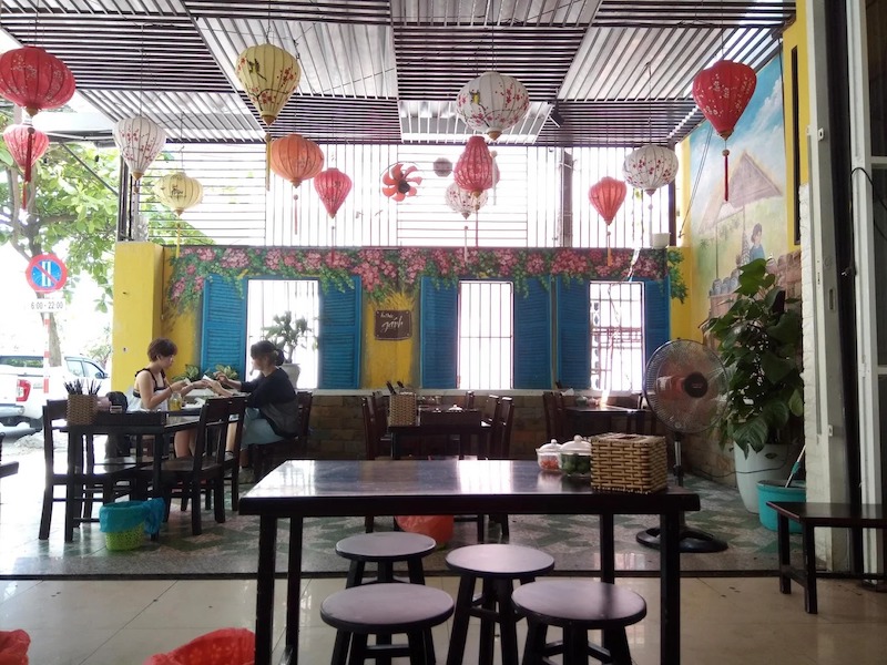 Sử dụng vật liệu tự nhiên, bàn ghế phù hợp, ánh sáng ấm, tranh tường, decor dân gian, tạo không gian thân thiện, gần gũi và thu hút khách