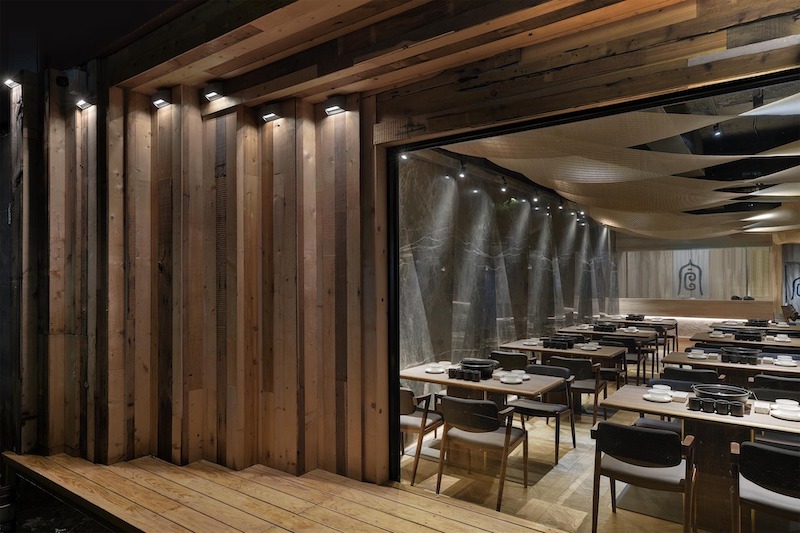 Sử dụng bàn ghế gỗ mộc, kiểu dáng đơn giản giúp quán lẩu nướng đem lại cảm giác gần gũi cho khách hàng