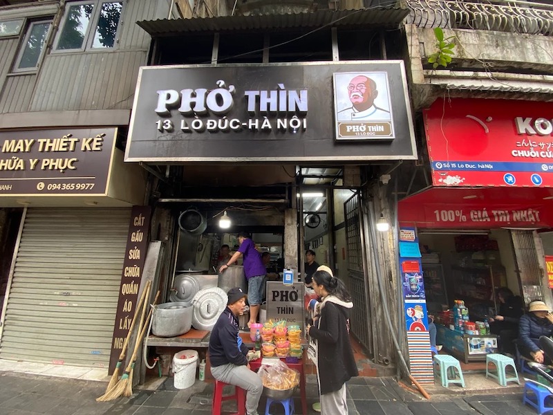 Thiết kế quán Phở Thìn 13 Lò Đúc mang đặc trưng mặt tiền nhà ống phố cổ, biển hiệu nền tối chữ nổi rõ ràng, không gian mở ra vỉa hè, vật liệu mộc mạc và bố cục ưu tiên công năng