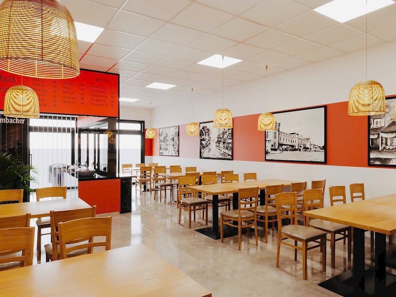Không gian quán phở được thiết kế hiện đại, sạch sẽ với bàn ghế gỗ đồng bộ, đèn mây tre trang trí, gam màu ấm và bố cục gọn gàng, dễ phục vụ 