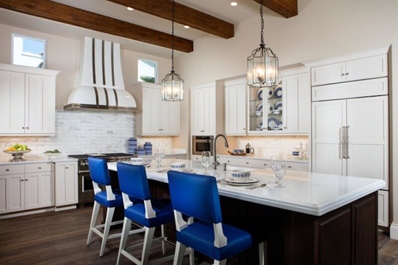 Không gian bếp với tông trắng chủ đạo, dầm gỗ trần và đảo bếp rộng, mang lại cảm giác ấm áp, thoáng đãng