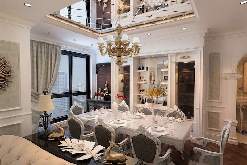 Không gian phòng ăn gây ấn tượng với bộ bàn ghế chạm khắc tinh xảo và đèn chùm đồng cổ điển, tôn lên vẻ sang trọng, chỉn chu