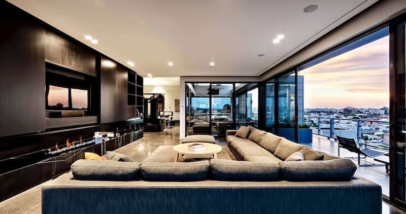 Sofa chữ L kích thước lớn được bố trí để tạo không gian trò chuyện, tối ưu tầm nhìn ra view thành phố và kết nối với khu vực lò sưởi 