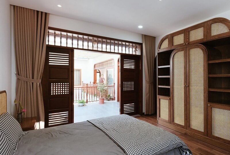 Phòng ngủ mang đậm hơi thở Á Đông với cửa gỗ pano chớp, đón gió và ánh sáng tự nhiên từ hiên ngoài vào