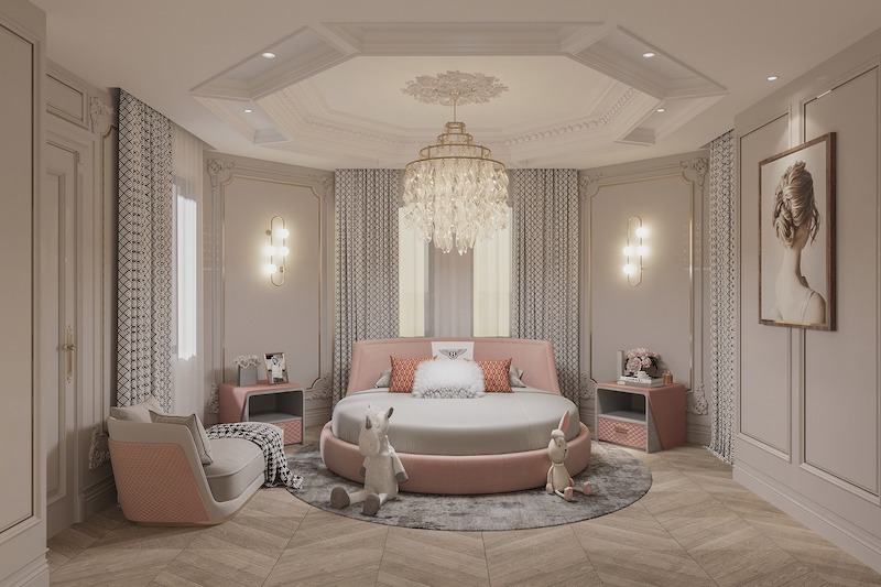 Không gian tân cổ điển nhẹ nhàng với giường tròn bọc nệm hồng pastel làm trung tâm, kết hợp đèn chùm pha lê và phào chỉ tinh tế, tạo cảm giác như phòng ngủ công chúa cho bé gái
