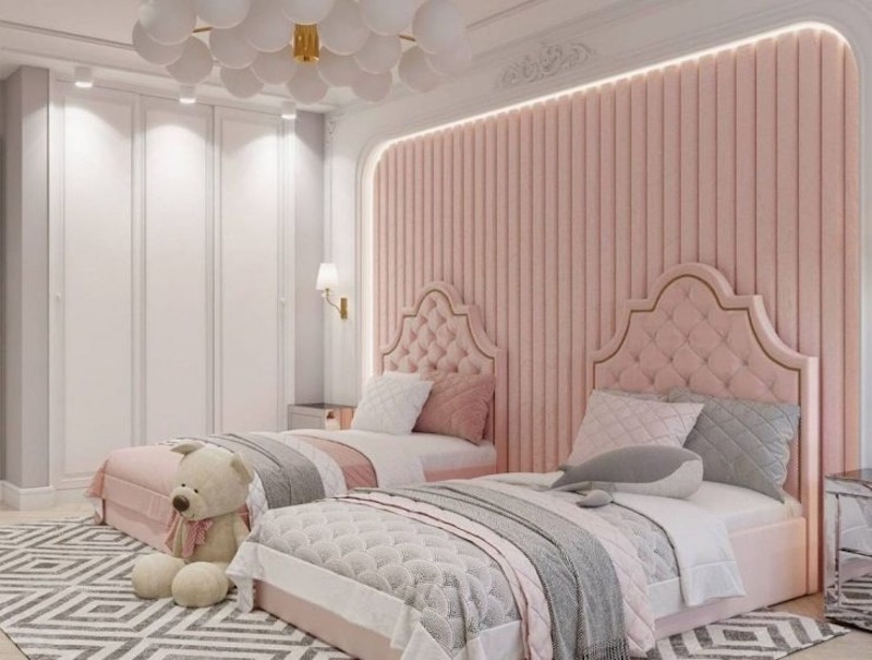 Hai giường đơn bọc nệm hồng phấn, đầu giường rút trám kết hợp mảng ốp cong bo mềm và ánh sáng hắt, mang lại cảm giác trang nhã, ấm áp, chuẩn gu tân cổ điển trẻ trung