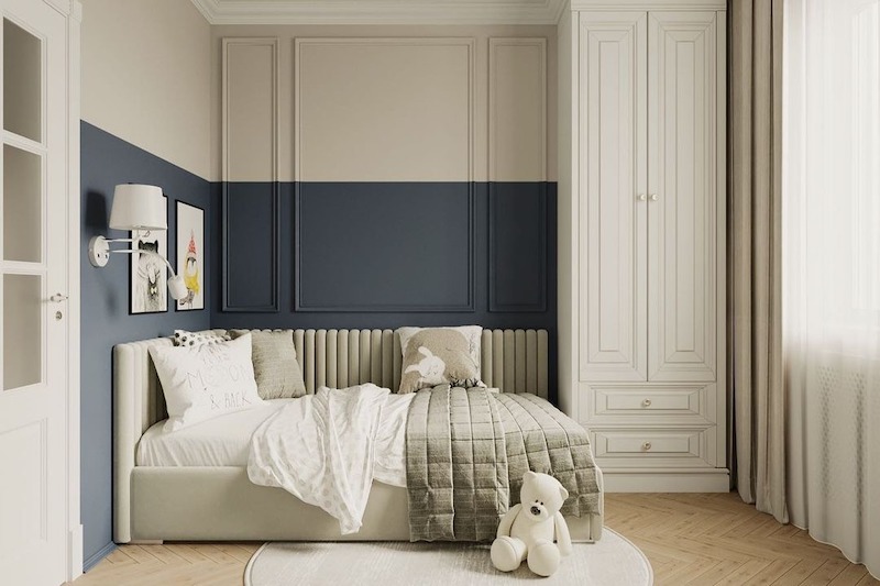 Mảng tường chia tone xanh trầm kết hợp phào chỉ gọn gàng, hệ tủ cao kịch trần đồng bộ màu sáng giúp không gian ngăn nắp, ánh sáng tự nhiên được tiết chế dịu mắt