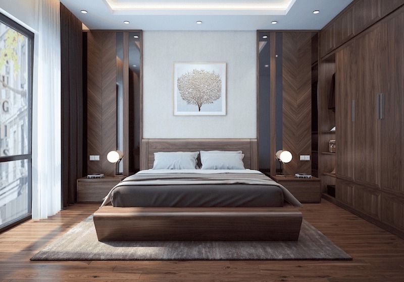 Không gian phòng ngủ ấm áp với gỗ óc chó vân xương cá, bố cục đối xứng tinh gọn, ánh sáng hắt trần dịu nhẹ tạo cảm giác thư giãn tuyệt đối