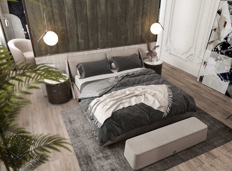 Giường bọc vải trung tính kết hợp đầu giường ốp nhung gân dọc, đèn thả tròn ánh vàng, tab bo cong nhỏ gọn và thảm mềm tạo cảm giác ấm cúng, cân bằng