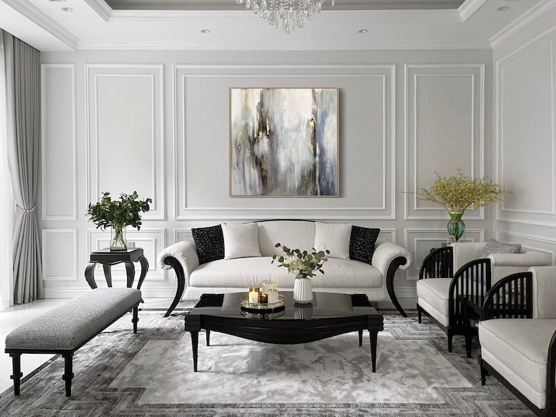 Không gian phòng khách tân cổ điển hiện đại dùng gam trung tính, phào chỉ tinh giản, nội thất uốn cong, điểm nhấn tranh trừu tượng, ánh sáng dịu tạo cảm giác sang trọng