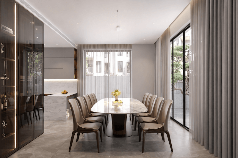 Bàn ăn mặt đá trung tâm kết hợp ghế bọc da thanh lịch, ánh sáng tự nhiên xuyên qua lớp rèm mỏng, tôn lên vẻ hiện đại, tinh giản và sang trọng