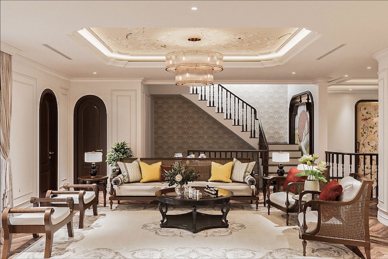 Không gian phòng khách Indochine sang trọng với nội thất gỗ tối màu, mây đan, họa tiết Á Đông, gam kem ấm và đèn trần cổ điển tinh tế