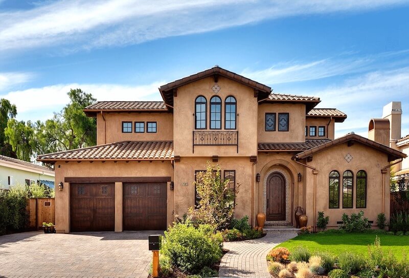 Villa nổi bật với mái ngói đất nung, tường stucco ấm áp, cửa vòm cổ điển và sân vườn xanh mát, hài hòa thiên nhiên