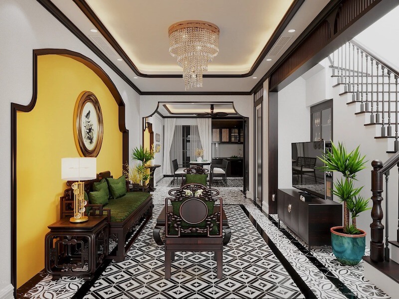 Bộ ghế gỗ chạm khắc tinh xảo với đệm xanh lục trở thành điểm nhấn trung tâm, gợi rõ tinh thần Indochine trang nhã và chiều sâu văn hoá Á Đông