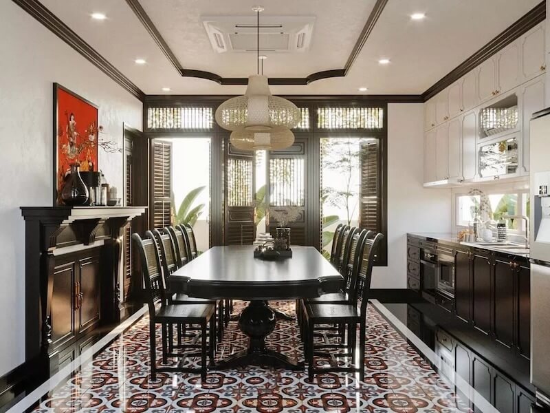 Chiếc bàn ăn gỗ sơn đen dáng dài, kết hợp ghế tựa nan thẳng, trở thành trục trung tâm định hình vẻ đẹp Indochine chỉn chu và trang trọng cho không gian