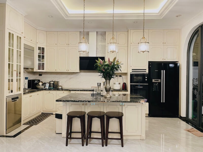 Không gian sử dụng vòm cong, khung đen, cây xanh và bố cục đối xứng, kết hợp vật liệu tự nhiên gợi tinh thần Á Đông, tạo cảm giác Modern Indochine nhẹ nhàng