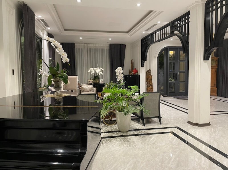 Không gian nổi bật với vòm cong đen, nan gỗ trang trí, cây xanh nhiệt đới và bố cục mở, pha trộn tinh thần Á Đông cùng đường nét hiện đại