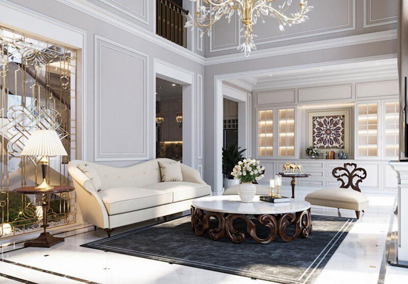 Không gian phòng khách thanh lịch với phào chỉ trắng tinh tế, sofa uốn cong mềm mại, bàn trà chạm khắc nghệ thuật và đèn chùm pha lê tôn lên vẻ đẹp sang trọng, chuẩn mực