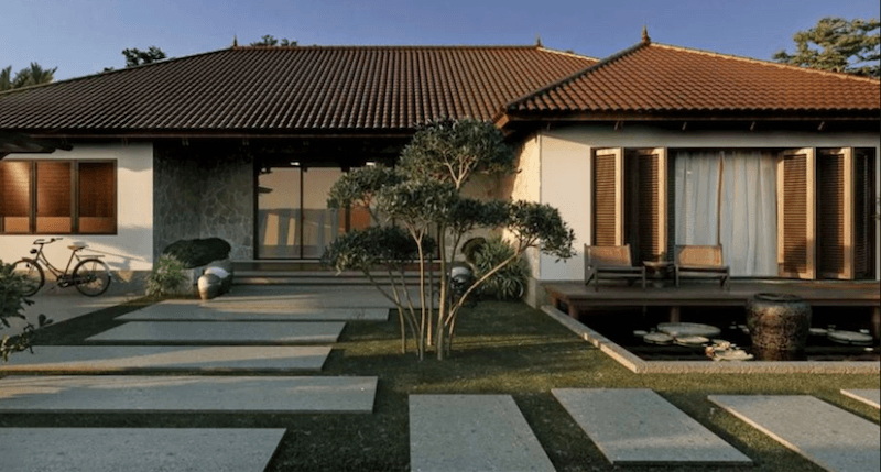 Biệt thự một tầng phong cách Nhật hiện đại gây ấn tượng với mái ngói nâu dốc nhẹ, hiên gỗ rộng mở và hồ nước tĩnh lặng, tạo nên không gian sống an yên, gần gũi thiên nhiên