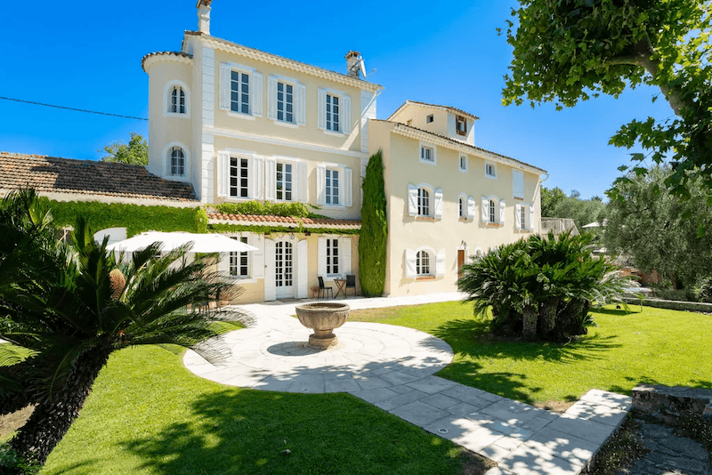 Biệt thự sân vườn Pháp cổ điển trong hình mang đậm tinh thần miền Nam nước Pháp với gam vàng kem ấm áp, mái ngói đỏ và hệ cửa chớp trắng thanh lịch