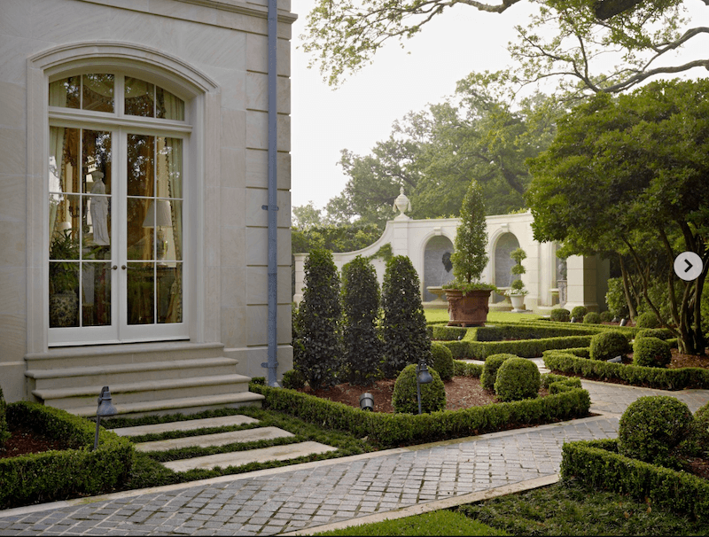 Không gian sân vườn phía trước được tổ chức gọn gàng với cây cắt tỉa tròn chuẩn mực, tạo nên tổng thể vừa lãng mạn vừa đậm chất dinh thự châu Âu