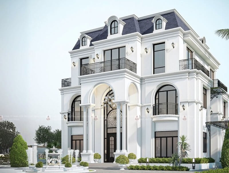 Mảng tường trắng tinh khôi kết hợp hệ cột đôi cao vút tạo thế đứng uy nghi, tôn trọn cửa vòm sắt nghệ thuật như điểm nhấn quyền quý nơi tiền sảnh