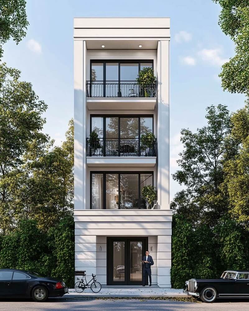 Hình khối thẳng đứng, bố cục đối xứng và phào chỉ tiết chế tạo nên vẻ sang trọng chuẩn tân cổ điển, trong khi cửa kính lớn và ban công sắt thanh mảnh mang hơi thở đương đại