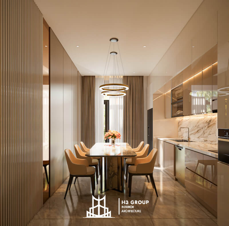Bàn ăn đá đặt trung tâm cùng đèn thả vòng tròn tạo điểm nhấn tinh tế, trong khi hệ tủ kịch trần và ánh sáng gián tiếp giúp tổng thể gọn gàng, thanh lịch và đầy cảm giác cao cấp