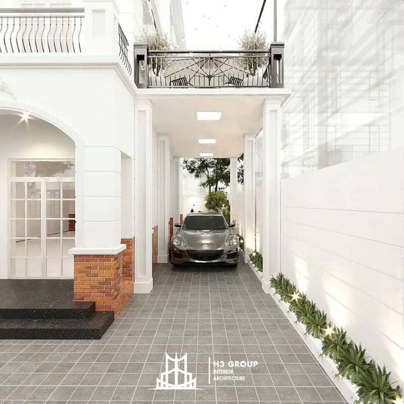 Không gian lối vào được thiết kế như một hành lang đỗ xe sang trọng với hệ cột vuông, lan can sắt nghệ thuật và gam màu trắng đặc trưng của kiến trúc châu Âu